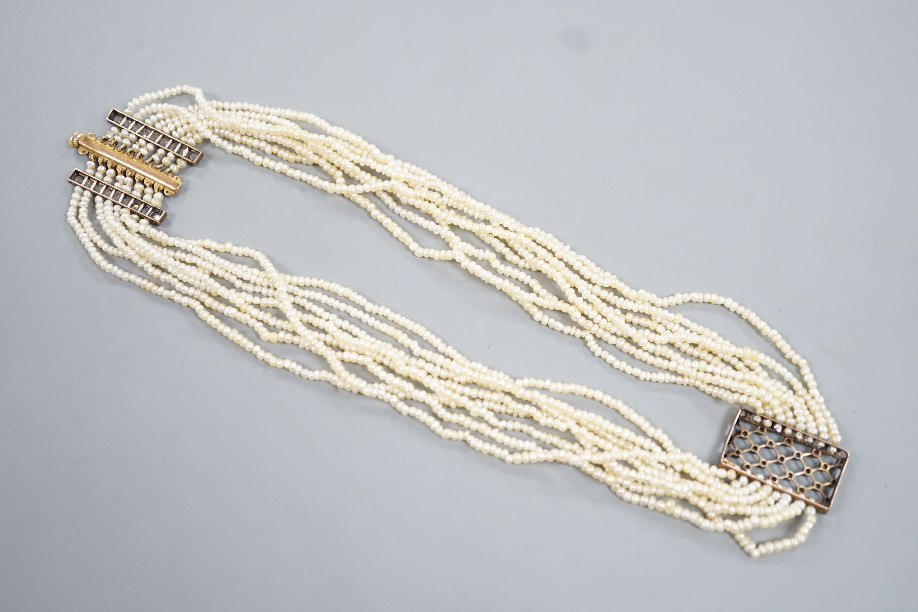 A 19th century multi-strand seed pearl choker necklace with yellow metal and rose cut diamond set clasp and trellis motif, approx. 40cm, gross weight 31.1 grams.